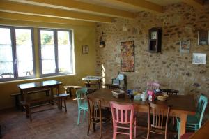 una sala da pranzo con tavoli in legno e sedie colorate di La Jameliniere a Chailland
