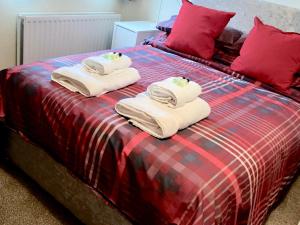 Una cama con toallas y almohadas. en Ashbrook House Apartments, en Dungannon
