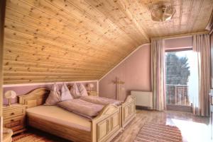 - une chambre avec un lit et un plafond en bois dans l'établissement Haus Regenbogen, à Mariapfarr