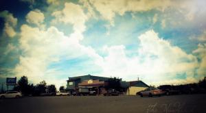 ein wolkiger Himmel mit Autos auf einem Parkplatz in der Unterkunft Windbreak Cafe in Wasilla