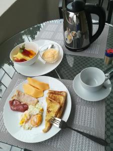 zwei Teller mit Frühstückslebensmittel auf einem Tisch in der Unterkunft Angel Guest House in Maputo