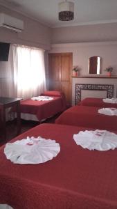 a hotel room with two beds with red sheets at Posada La Casona in Salta