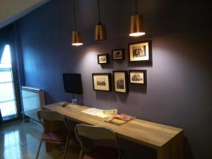 Habitación con una mesa con sillas y cuadros en la pared. en Hostal Catalina de Austria en Torquemada