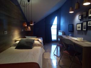 a bedroom with two beds and a desk with a desk at Hostal Catalina de Austria in Torquemada