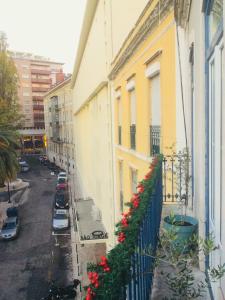 リスボンにあるCentral Lisbon Classic Apartmentの建物の横に赤い花が咲くバルコニー