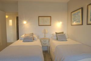 マラガにあるApartamento Malaguetaのベッドルーム1室(ベッド2台、テーブルの上にランプ付)