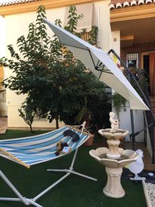 a hammock and a fountain in a yard at VILLA HISPANO-BRASILEÑA-Fiestas NO in Purchil