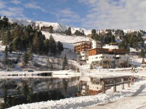 Un edificio nella neve vicino a un corpo d'acqua di Sundance Mountain Resort a Turracher Hohe