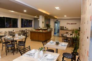 a restaurant with tables and chairs and a counter at Hotel Plaza Cascavel in Cascavel