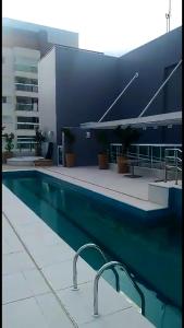 a swimming pool in front of a building at Studio mobiliado in Santos