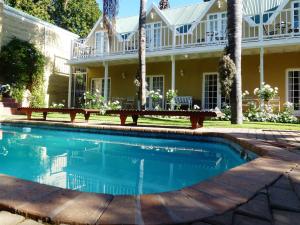 - une piscine avec une table de pique-nique en face d'une maison dans l'établissement @Yamkela Guest House, à Oudtshoorn