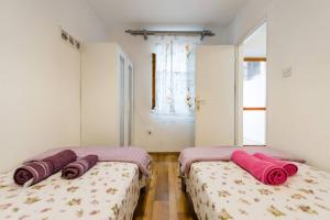 two beds sitting next to each other in a room at Apartment Pjaca in Postira