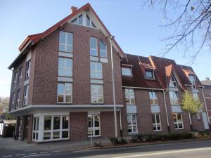 a red brick building with white windows on a street at City Boardinghouse Alsdorf in Alsdorf