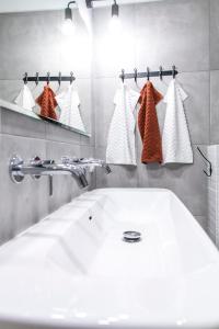 ein Badezimmer mit einem weißen Waschbecken und einem Spiegel in der Unterkunft Family Luxury Comfort Old Town Apartament, 1-8, 2 sypialnie i salon, parking w cenie, SUMMERWINTER Brand in Danzig