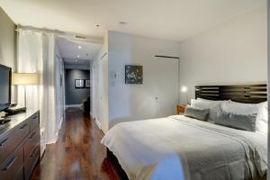 a bedroom with a large bed and a flat screen tv at Les Immeubles Charlevoix - Le 1175 in Quebec City