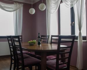 ヴィスワにあるApartament Premium Deluxのダイニングルームテーブル(椅子付)、ワイン1本