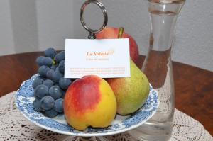 a plate of fruit on a table with a key chain at La Solatìa in Porto Ceresio