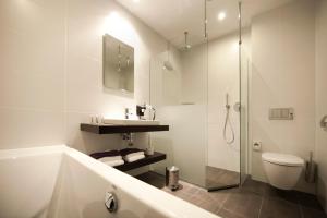 ein Bad mit einer Badewanne, einem WC und einer Dusche in der Unterkunft Hotel Bella Ciao in Harderwijk