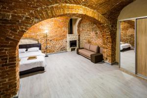 um quarto com uma cama e uma parede de tijolos em Stylish apartment - Rynok Square 44 em Lviv