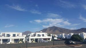 una fila di edifici bianchi con montagne sullo sfondo di Casa Avellana a Playa Blanca