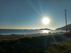 una playa con el sol saliendo sobre el océano en Residencial Drops De Aniz, en Florianópolis