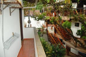 a balcony of a building with a bench and trees at Casa do Frá in Morro de São Paulo