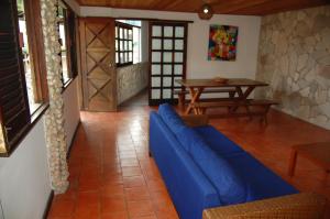 sala de estar con sofá azul y mesa en Casa do Frá, en Morro de São Paulo