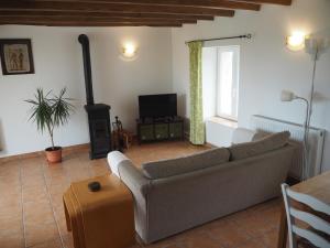 a living room with a couch and a stove at Villas de Leypinas Gites in Saint-Pardoux-Corbier