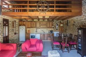 cocina con sillas rojas y mesa en la cocina en Writers' Retreat in Xilokastro, en Xylokastro