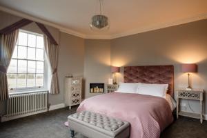 a bedroom with a bed and a large window at B&B Downham Hall in Wickford