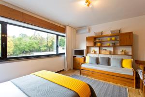 a bedroom with a bed and a large window at JS Apartment in Coimbra