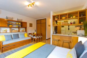 JS Apartment في كويمبرا: غرفة معيشة مع أريكة ومطبخ