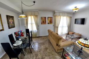 uma sala de estar com um sofá e uma mesa em Chalet El Naranjo em Sevilha