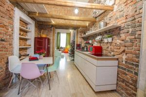 a kitchen with a brick wall and a table and chairs at Michael Weiss apartment in Braşov