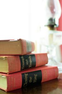 four books stacked on top of each other on a table at Sir Edgar House B&B in Dauphin