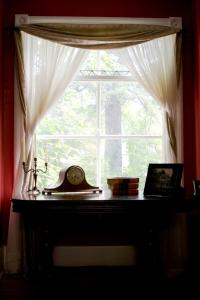 a window with a clock on top of a table at Sir Edgar House B&B in Dauphin