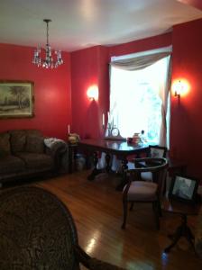 a living room with red walls and a table at Sir Edgar House B&B in Dauphin