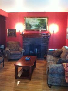a living room with a fireplace with two couches and a table at Sir Edgar House B&B in Dauphin