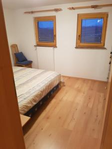 a bedroom with a bed and a wooden floor at Hiška na gorci in Podčetrtek