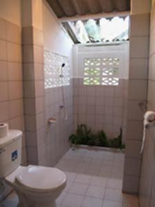 a bathroom with a toilet and a shower with a window at Mairood Resort in Ban Mai Rut