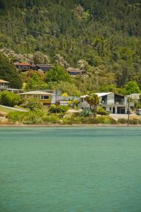 un gruppo di case su una collina vicino all'acqua di Abel Tasman Kaiteriteri B & B a Kaiteriteri