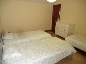 una camera da letto con due letti e un comò di Le Refuge a Champagné-Saint-Hilaire