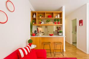 sala de estar con sofá rojo y cocina en Sereia Garden Apartment, en Coímbra