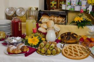 a table topped with bread and pastries and milk at Hotel Sylesia in Letojanni