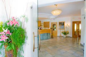 a hallway of a home with flowers and a kitchen at Hotel Willy in Sesto