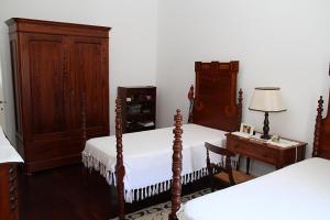 um quarto com 2 camas e uma secretária com um candeeiro em Ponta Delgada - Casa Rural em Ponta Delgada