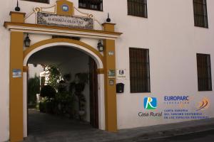 un accès à un bâtiment avec une arche dans l'établissement Hacienda Olontigi, à Aznalcázar