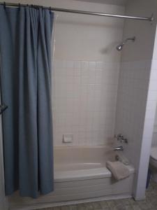 a bathroom with a bath tub with a shower curtain at Rosedale Manor in Duncan