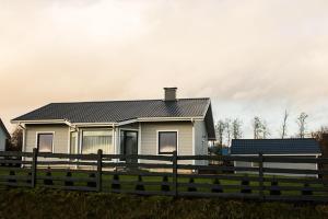 a white house with a fence in front of it at Estate Holiday home in Kuldīga