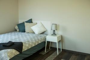 a bedroom with a bed and a table with a lamp at Estate Holiday home in Kuldīga